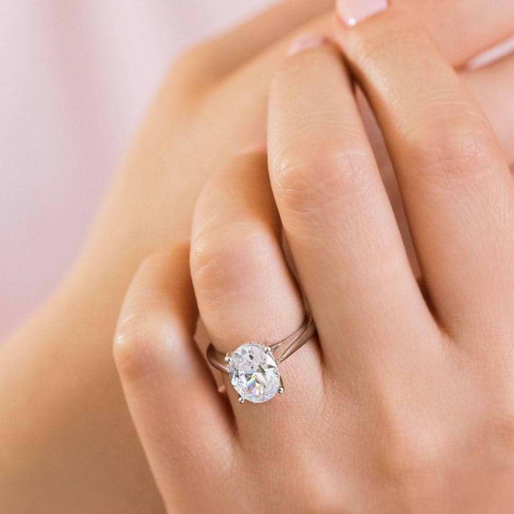 Shown with 2ct Oval Cut Lab Grown Diamond in 14k Rose Gold|Stunning unique two tone hidden halo engagement ring with 2ct oval cut lab grown diamond in 14k rose gold worn on hand