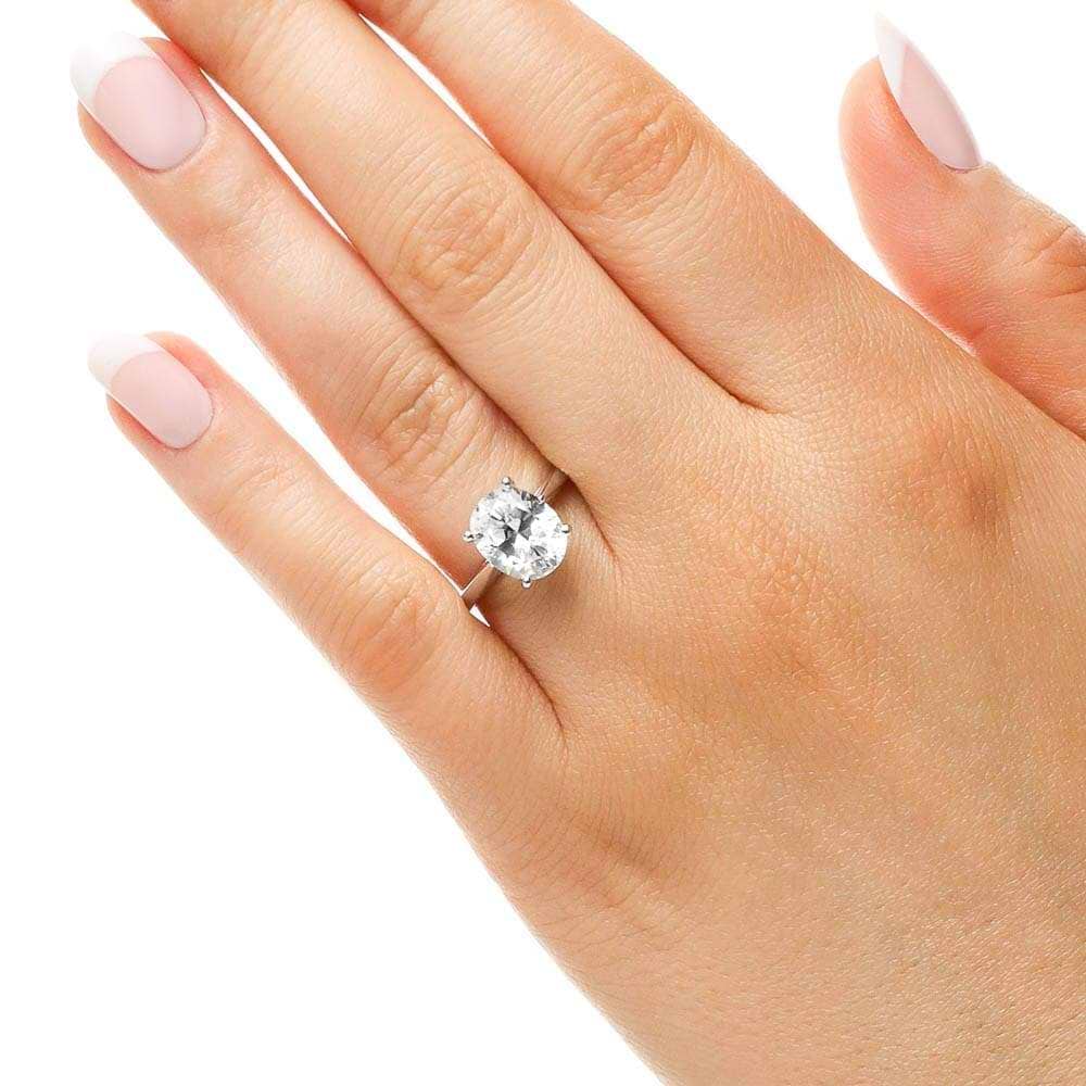 Shown with 2ct Oval Cut Lab Grown Diamond in 14k White Gold|Two tone hidden halo engagement ring with 2ct oval cut lab grown diamond in 14k white gold worn on hand