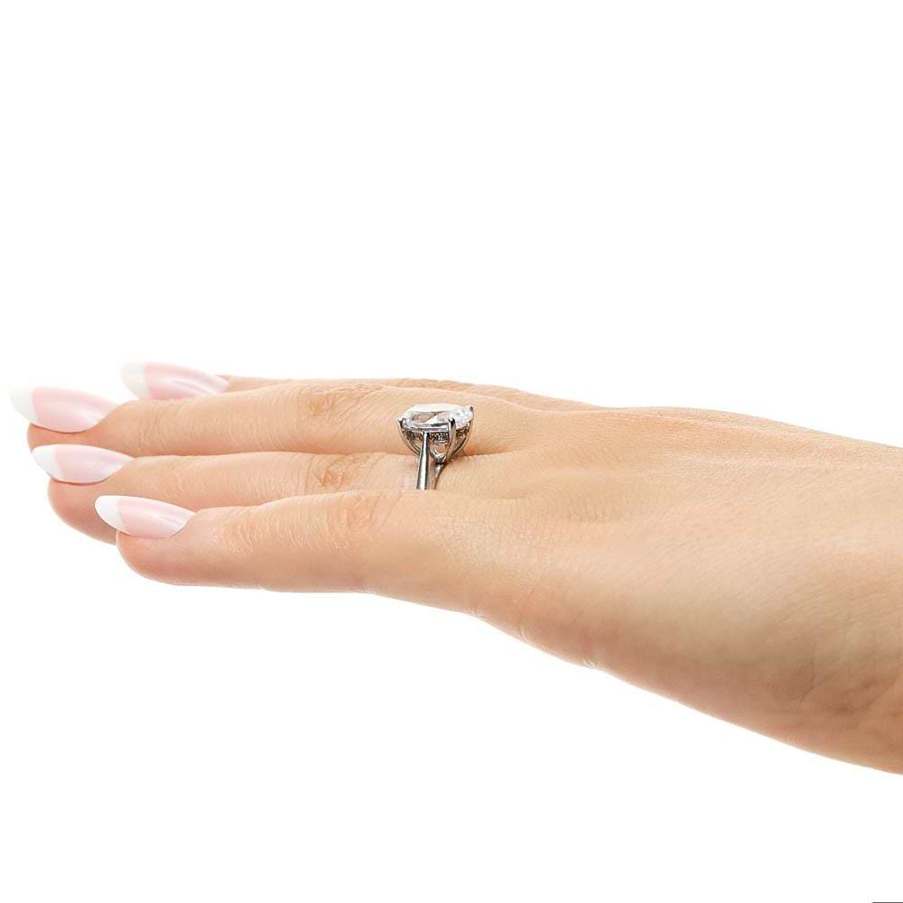 Shown with 2ct Oval Cut Lab Grown Diamond in 14k White Gold|Two tone hidden halo engagement ring with 2ct oval cut lab grown diamond in 14k white gold worn on hand sideview