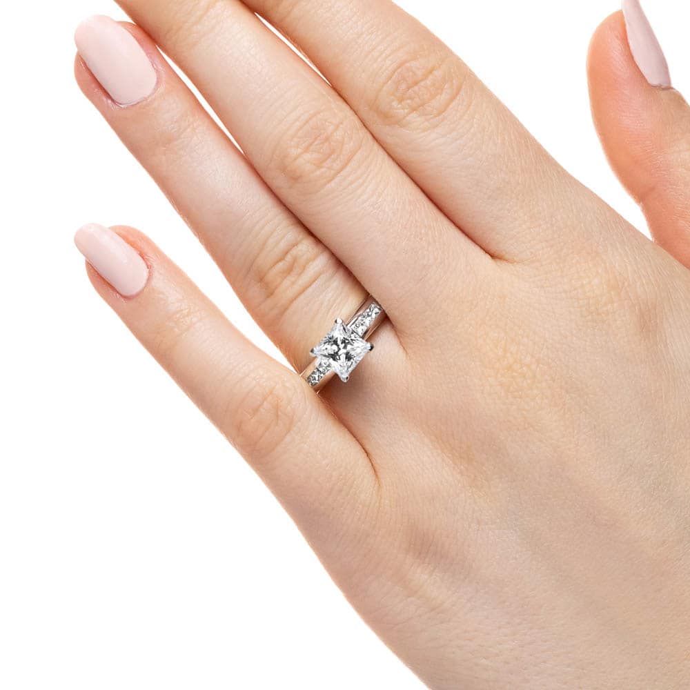Shown with 1ct Princess Cut Lab Grown Diamond in 14k White Gold|Cathedral style engagement ring with 1ct princess cut lab diamond in channel set diamond accented 14k white gold band worn on hand