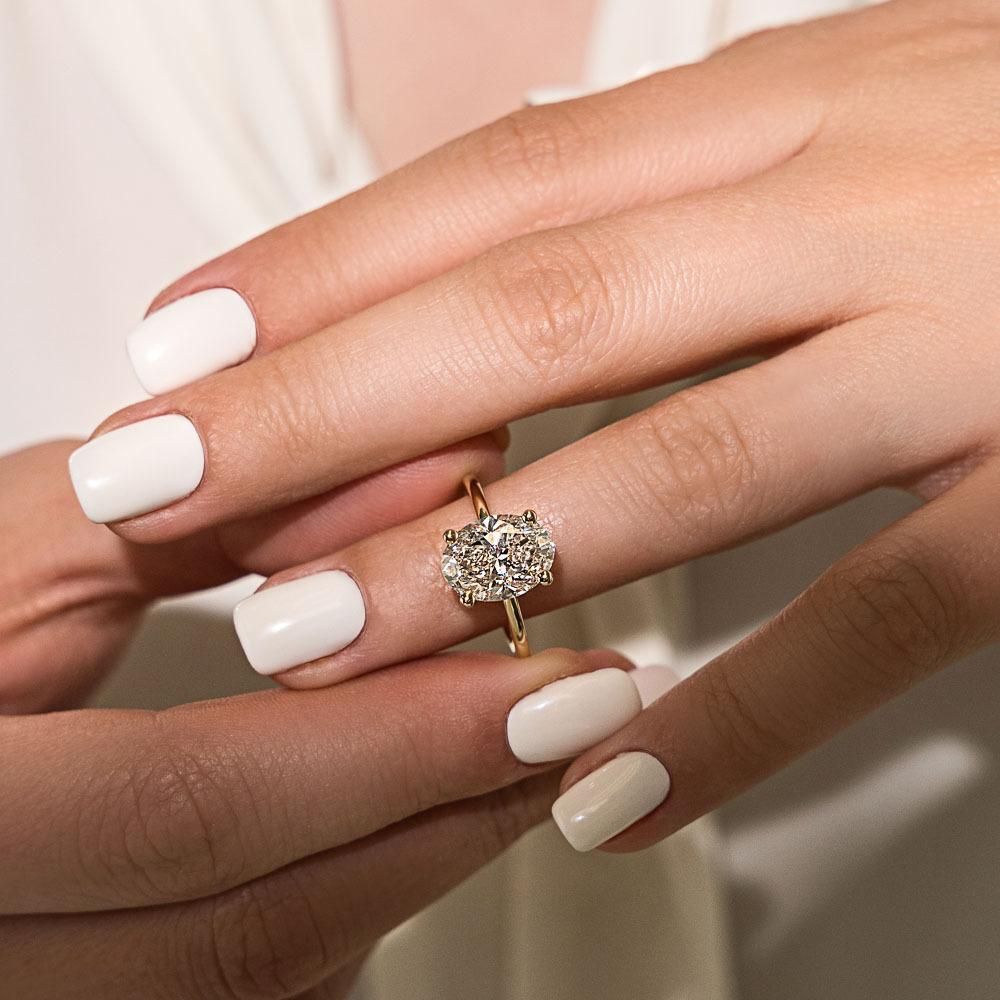 Millie Accented Hidden Halo Engagement Ring shown with a 3.0ct oval cut Lab-Grown Diamond with a hidden halo in recycled 14K yellow gold | Millie hidden halo engagement ring 3.0ct oval cut Lab-Grown Diamond recycled 14K yellow gold