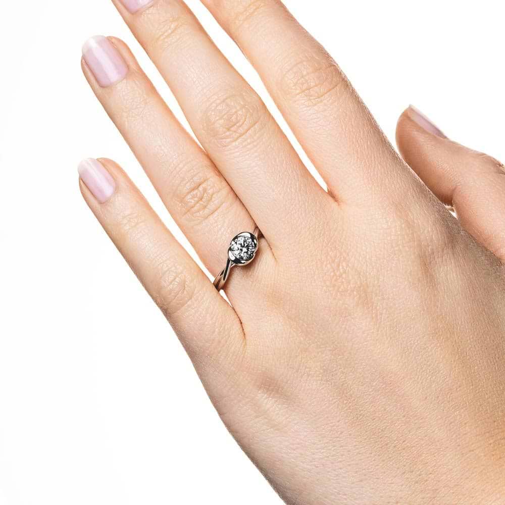 Shown with 1ct Round Cut Lab Grown Diamond in Platinum|Modern engagement ring with twisted band design holding a 1ct round cut lab grown diamond in platinum setting worn on hand