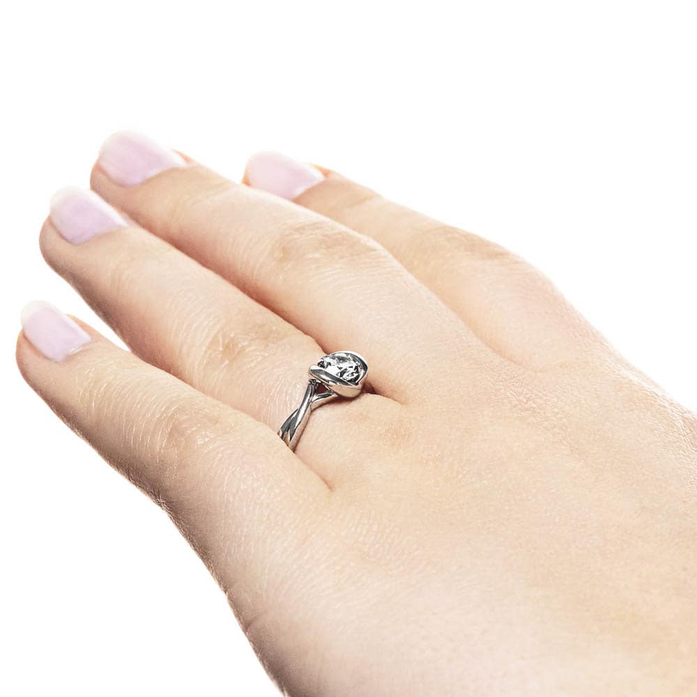 Shown with 1ct Round Cut Lab Grown Diamond in Platinum|Modern engagement ring with twisted band design holding a 1ct round cut lab grown diamond in platinum setting worn on hand sideview