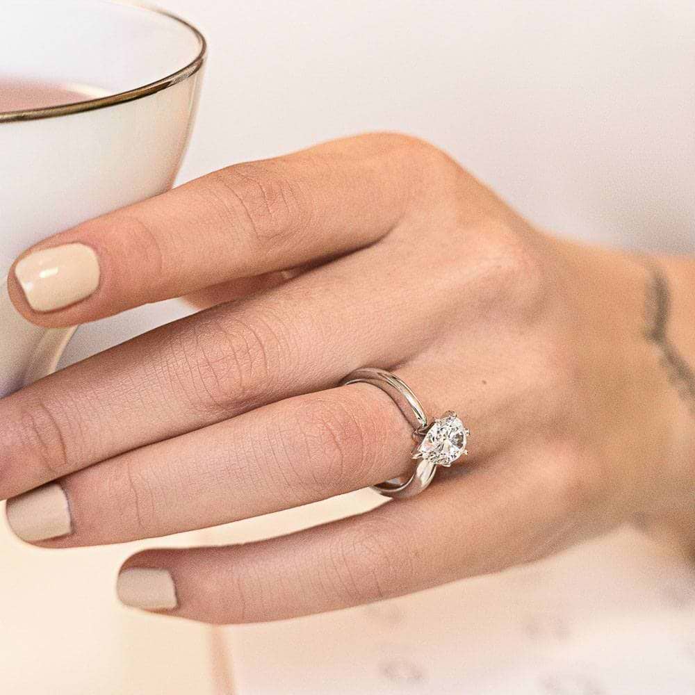 Shown with 1ct Pear Cut Lab Grown Diamond in 14k White Gold|Minimalistic traditional solitaire engagement ring with 6 prong set 1ct pear cut lab grown diamond in 14k white gold band worn on hand