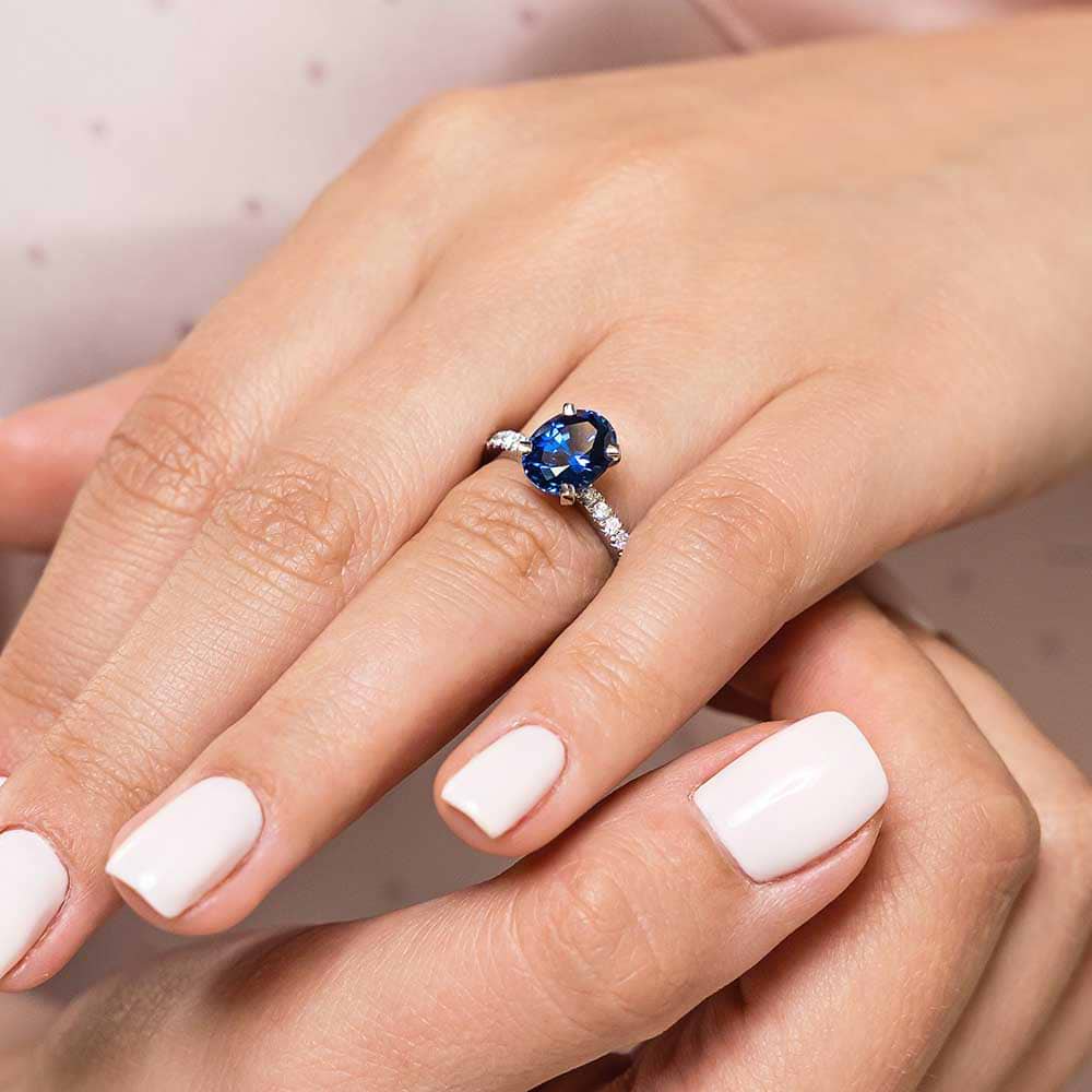 Shown here with an oval 3ct lab-created blue sapphire | affordable blue sapphire engagement ring