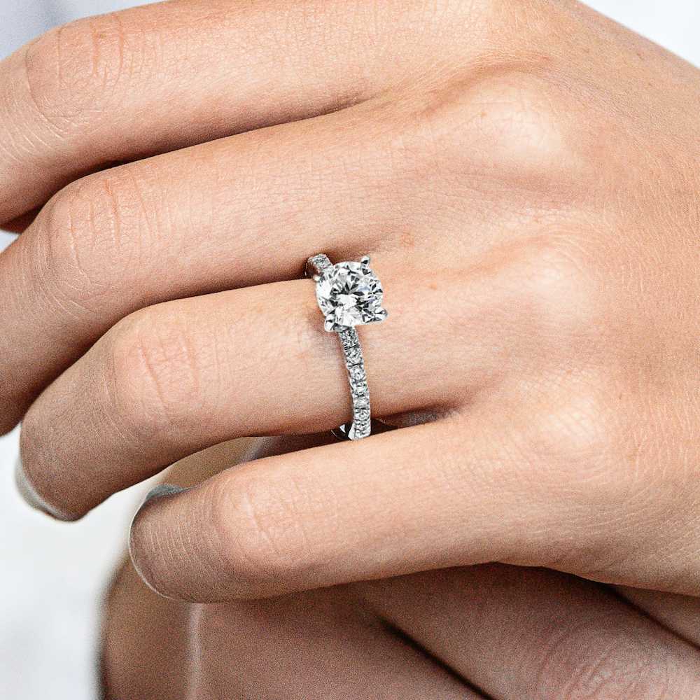 Shown with 1ct Round Cut Lab Created Diamond in 14k White Gold|Ethical affordable diamond accented engagement ring with 1ct round cut lab created diamond center stone in 14k white gold worn on hand
