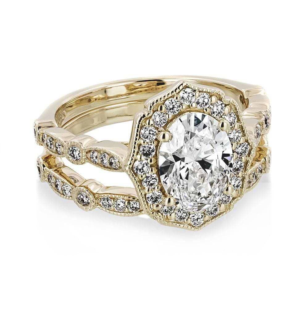 Shown with a 1.0ct Oval cut Lab-Grown Diamond with a diamond accented halo and filigree detailing in recycled 14K yellow gold with matching wedding band, can be purchased together at a discounted price