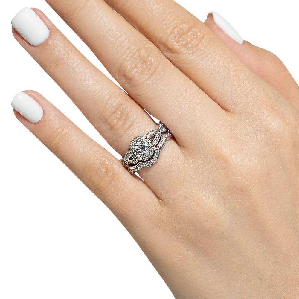 Shown with a 1.0ct Round cut Lab-Grown Diamond with a diamond accented halo and twisted band in recycled 14K white gold with matching wedding band 