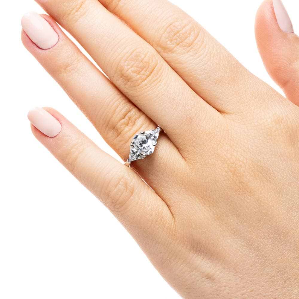 Shown with 1ct Oval Cut Lab Grown Diamond & 0.50ct Triangle Cut Side Stones in 14k White Gold|Three stone engagement ring with 1ct oval cut lab grown diamond and two 0.50 triangle cut diamond side stones in 14k white gold band worn on hand