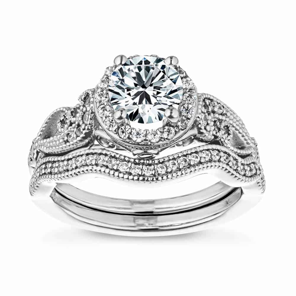 Shown with a 1.0ct Round cut Lab-Grown Diamond with diamond accented halo and filigree detailed band in recycled 14K white gold with matching wedding band, can be purchased together for a discounted price