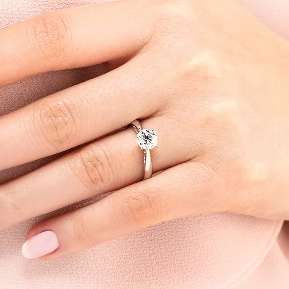 Shown with a 1ct Round Cut Lab Grown Diamond in 14k White Gold|Classic solitaire engagement ring with 1ct round cut lab grown diamond in cathedral style 14k white gold band shown worn on hand