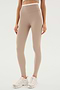 Person wearing ultra luxe, SPLITS59 Dual High Waist Airweight 7/8 - Latte/White leggings and white sneakers, standing against a plain white background.