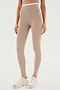 Person wearing ultra luxe, SPLITS59 Dual High Waist Airweight 7/8 - Latte/White leggings and white sneakers, standing against a plain white background.