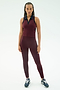 A woman faces forward in SPLITS59's Amber Airweight High Waist 7/8 leggings and top in Dark Cherry/Indigo, crafted from soft nylon spandex, paired with navy sneakers against a white background.