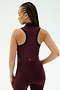 A woman with braided hair is seen from the back wearing the SPLITS59 Austin Airweight Crop Polo in Dark Cherry/Indigo against a plain light background.
