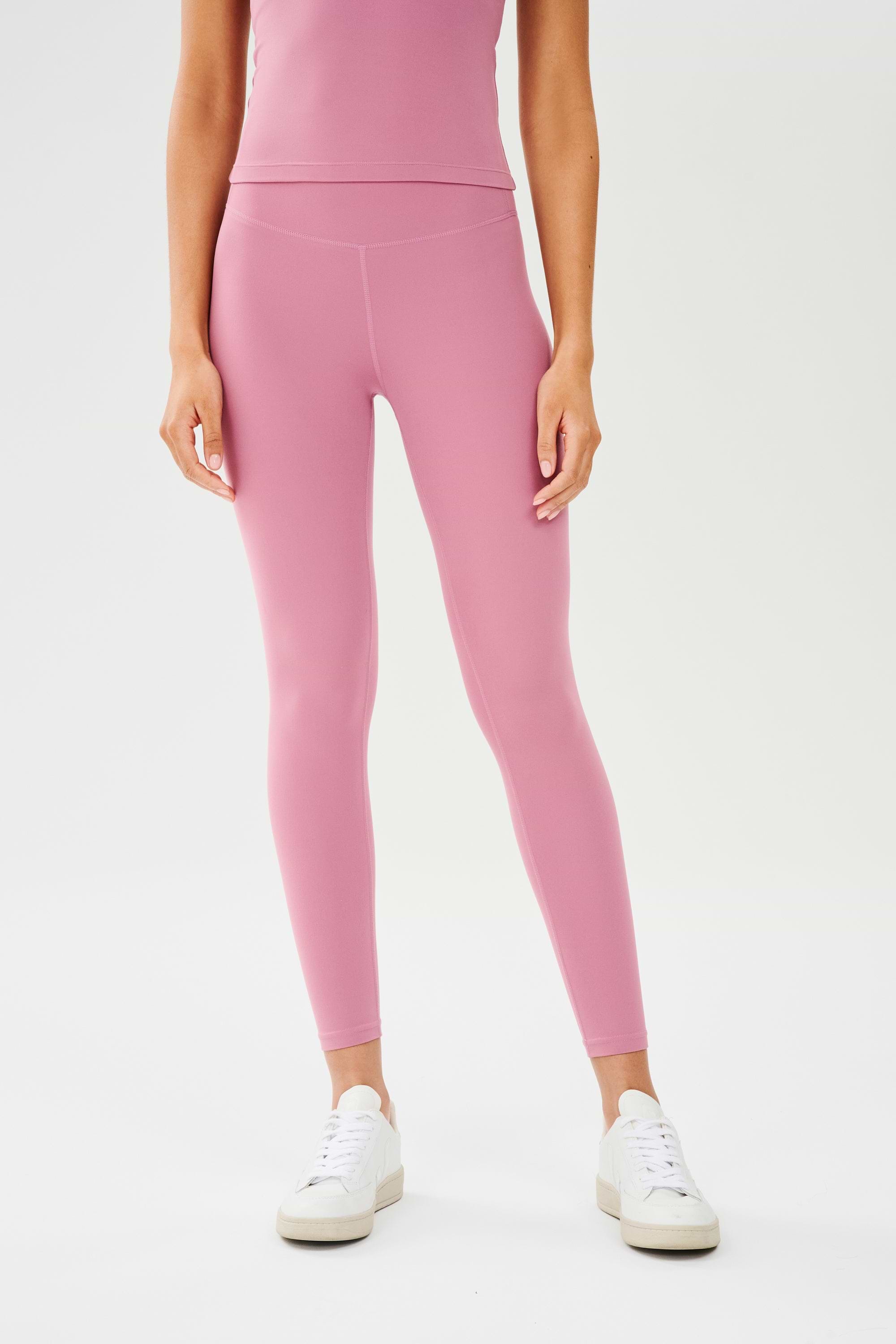  Front view of girl wearing highwasited pink leggings with white shoes