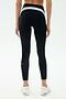 A person is seen from behind wearing SPLITS59 Emerson Airweight High Waist leggings in Black/Ice, featuring a light blue and white waistband—ideal for Pilates or hot yoga—posed against a white background.