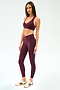 A woman wears the SPLITS59 Mia Rigor Bra in Dark Cherry, paired with leggings, both crafted from nylon and spandex.
