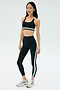 On a white background, a person wears the SPLITS59 Miles Rigor Bra - Black/White with matching striped leggings and silver athletic shoes—ideal for gym workouts and optimal support.