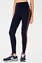 Side view of girl wearing dark blue leggings with two thin brown stripes down the side with dark blue shoes