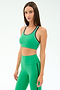 A woman wears the SPLITS59 Robbie Airweight Bra in Spearmint/Military with matching high-waisted leggings, standing and looking at the camera against a plain white background.