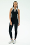 A person stands against a plain background wearing the SPLITS59 Amber Airweight High Waist 7/8 leggings in Black/White.