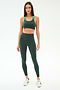 A woman faces forward wearing the SPLITS59 Amber Airweight High Waist 7/8 leggings in Military/Spearmint, paired with a matching sports bra and white sneakers, against a plain white background.