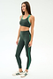 A woman stands in profile against a white background, wearing SPLITS59's Amber Airweight High Waist 7/8 leggings and sports bra in Military/Spearmint, crafted from a comfortable nylon-spandex blend.