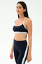 A woman stands in profile against a light background, wearing the SPLITS59 Emerson Airweight Bra in Indigo/Dove Grey with matching high-waisted leggings—ideal for hot yoga.