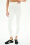 Person wears SPLITS59 Airweight Rib High Waist 7/8 leggings in white with black Adidas sneakers, standing against a plain white background. Upper body partially out of frame—ideal for Pilates or hot yoga.