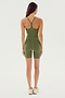 A person stands facing away, wearing the SPLITS59 Airweight 6” Short Jumpsuit in olive, complemented by beige sneakers.