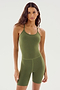 A person with long hair wears the SPLITS59 Airweight 6” Short Jumpsuit in Olive, a body-hugging, sleeveless design made from airweight fabric, standing against a plain white background.