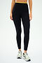 A person wearing SPLITS59's Easton Rigor High Waist 7/8 in Black/Chartreuse and white running shoes, ideal for high-impact workouts, stands against a plain background.