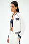 A woman stands against a plain background wearing the SPLITS59 Hayes Varsity Rigor Jacket in white, featuring "59" on the chest, paired with a navy crop top and white nylon pants with spandex accents.