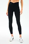 A person wearing SPLITS59 Mia Rigor Legging w/ Stripe in Black/White and white sneakers stands against a plain white background.