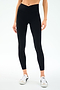 A person wearing SPLITS59 Mia Rigor Legging w/ Stripe in Black/White and white sneakers stands against a plain white background.