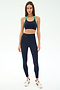 A woman faces forward wearing the SPLITS59 Amber Airweight High Waist 7/8 leggings in Indigo/Spearmint with matching sports bra, featuring an athletic nylon-spandex blend, and white sneakers on a plain white background.