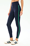 A person wears SPLITS59 Amber Airweight High Waist 7/8 leggings in Indigo/Spearmint, featuring a green side stripe, paired with white sneakers with navy stripes, standing against a white background.