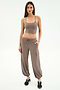 A woman faces forward wearing the SPLITS59 Airweight Crop in Lentil with matching taupe cargo pants and black sneakers against a white background—ideal for hot yoga or casual outings.