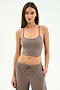 A woman with long brown hair models the SPLITS59 Airweight Crop in Lentil, paired with matching drawstring pants, standing against a plain light background.