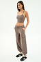 A woman poses against a white background in the SPLITS59 Airweight Crop - Lentil and matching cargo pants, paired with black sneakers with white stripes. Her hands in her pockets showcase an effortlessly cool look for hot yoga or casual outings.