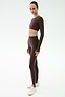 A person stands against a light background wearing the SPLITS59 Amelia Airweight Lite Shrug in Dark Chocolate paired with matching leggings and white sneakers—an ideal outfit for yoga or dance.