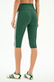 A person is shown from the back wearing SPLITS59 Ella High Waist Airweight Capri leggings in Arugula/White with white side stripes, paired with white sneakers featuring green stripes, combining sporty style and comfort.