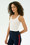 A person with curly hair wears a white SPLITS59 Ashby Rib Crop and navy athletic shorts with red stripes, standing against a plain light background.