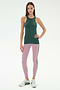 A woman stands against a white background wearing the SPLITS59 Kiki Rib Tank Full Length in Military, light purple yoga leggings with a dark stripe, and white sneakers.