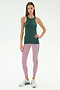 A woman stands against a white background wearing the SPLITS59 Kiki Rib Tank Full Length in Military, light purple yoga leggings with a dark stripe, and white sneakers.