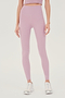Front view of woman with straight dark hair wearing light pink high waist legging and light pink bra tank paired with white shoes