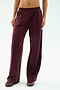 A person wearing SPLITS59's Luca Airweight Trouser with Stripe in Dark Cherry/Indigo, styled with matching maroon sneakers, shown from waist to feet against a plain background.