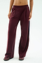 A person wearing SPLITS59's Luca Airweight Trouser with Stripe in Dark Cherry/Indigo, styled with matching maroon sneakers, shown from waist to feet against a plain background.