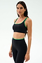 Woman wearing the SPLITS59 Cait Rigor Bra in Black/Grass, crafted from high performance Rigor fabric. Features supportive design ideal for high impact workouts. She stands against a plain light background, looking at the camera.